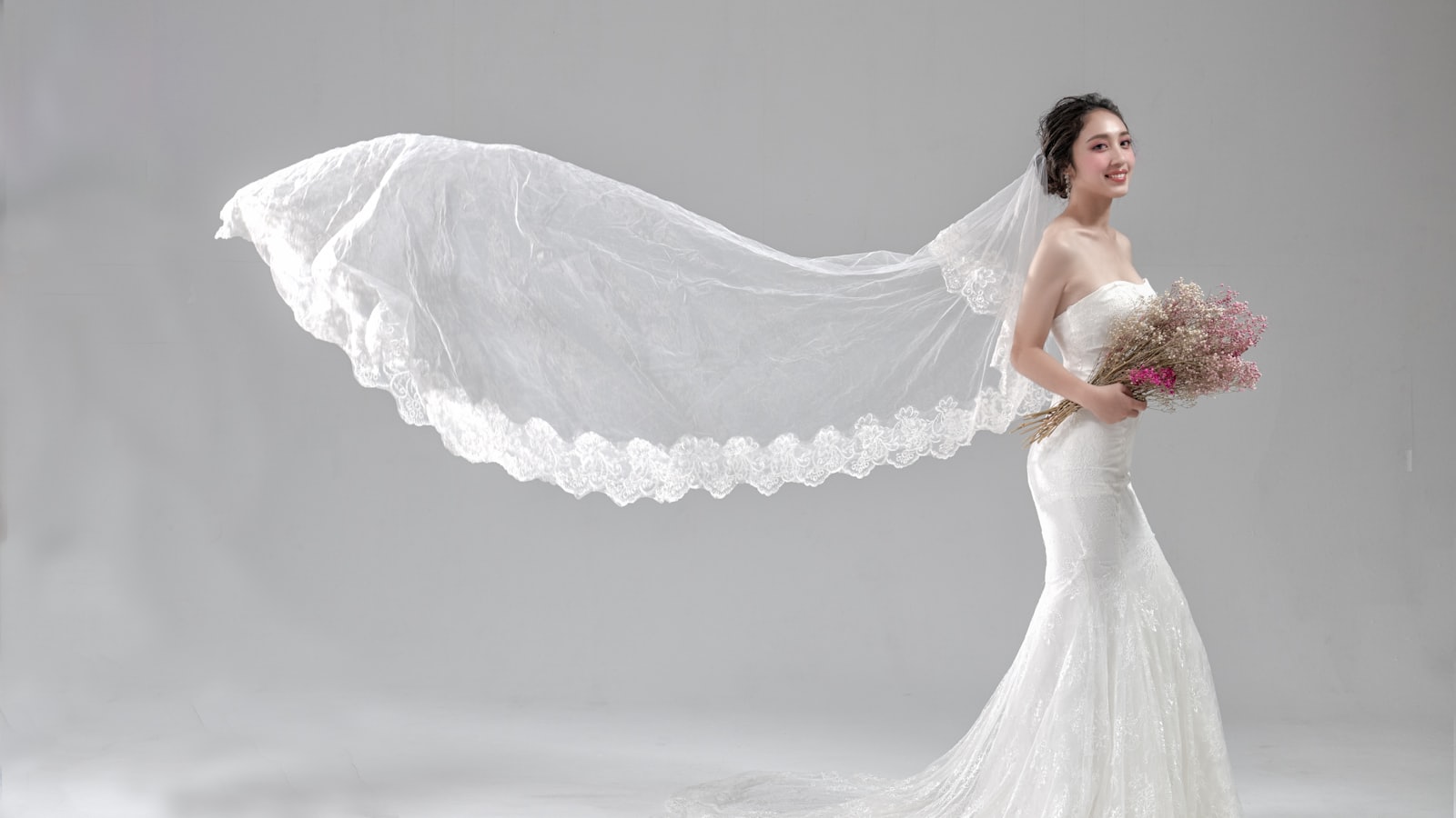 Noiva com vestido branco a segurar um ramo de flores